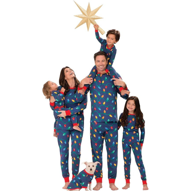 A family wearing matching pajamas posing with holiday decorations and a dog