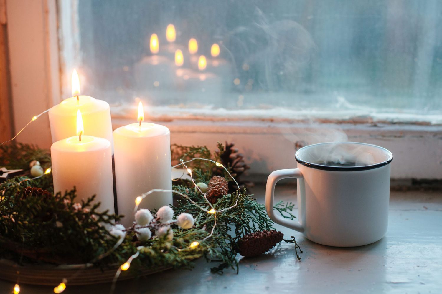 Tree scented candle burning by winter window