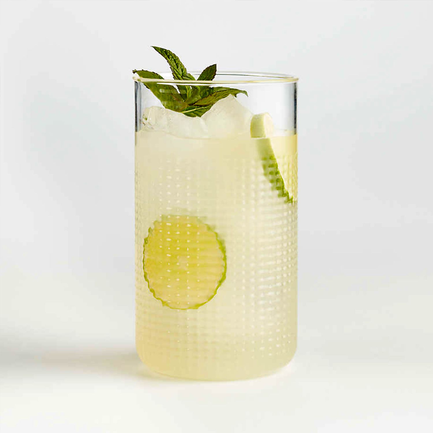 acrylic highball glass with yellow liquid and sliced fruit