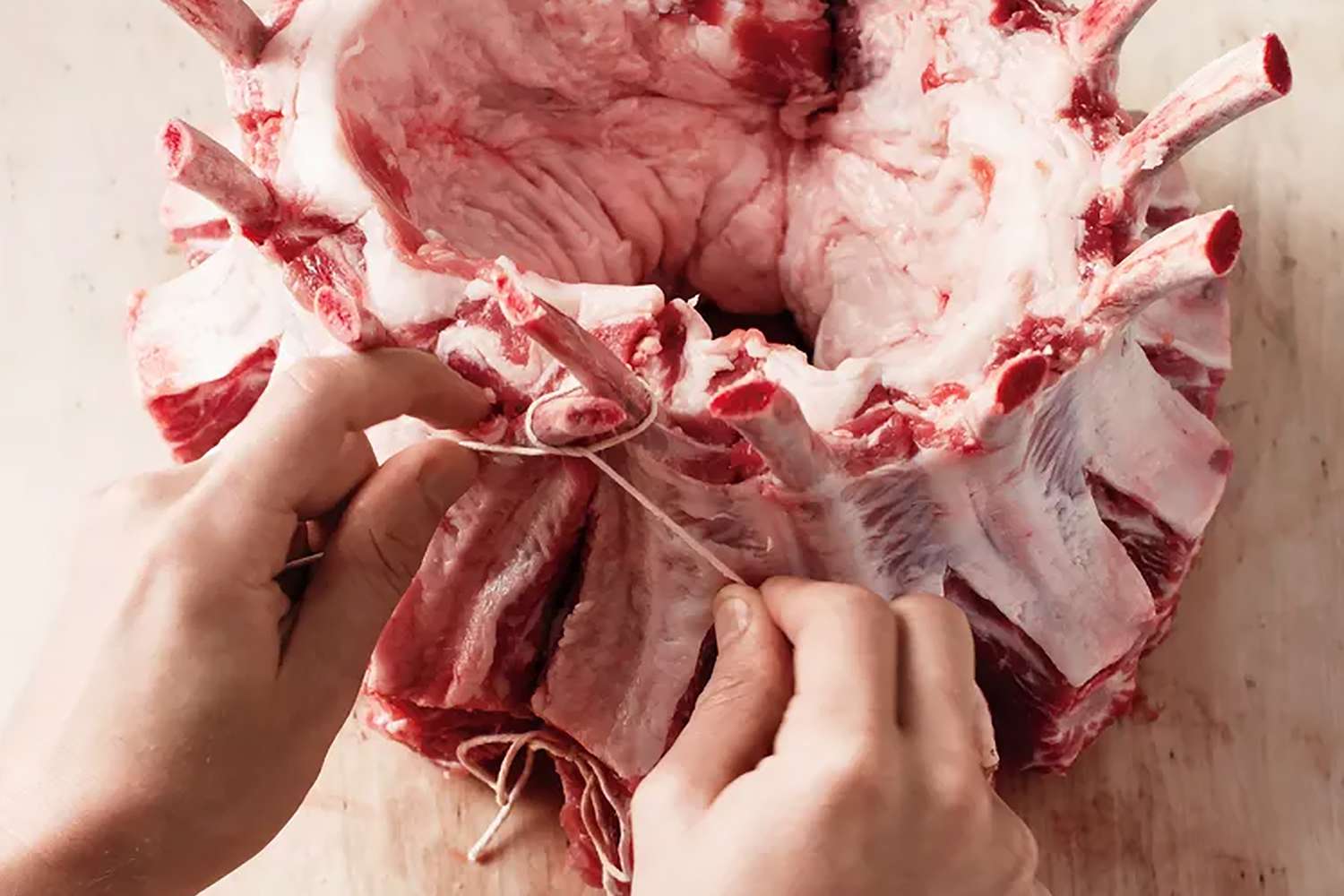 overhead view of someone tying a pork roast