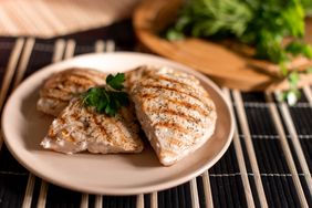 Grilled chicken breasts garnished with parsley on a plate