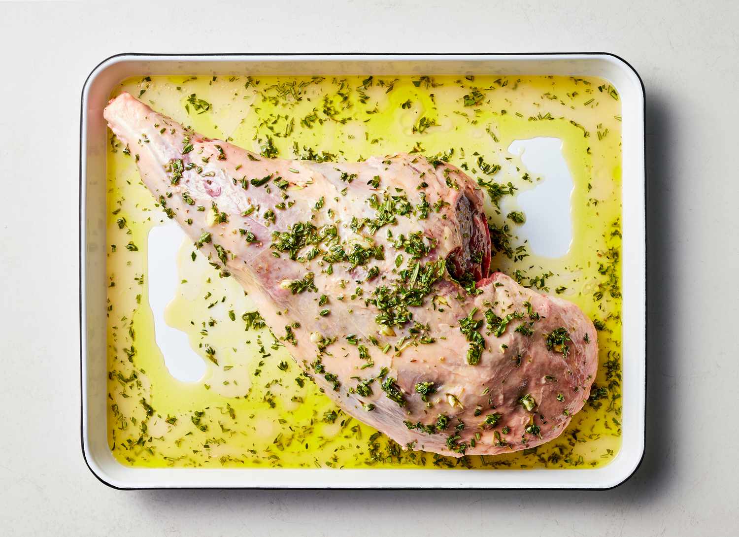 raw leg of lamb with herb mix on top