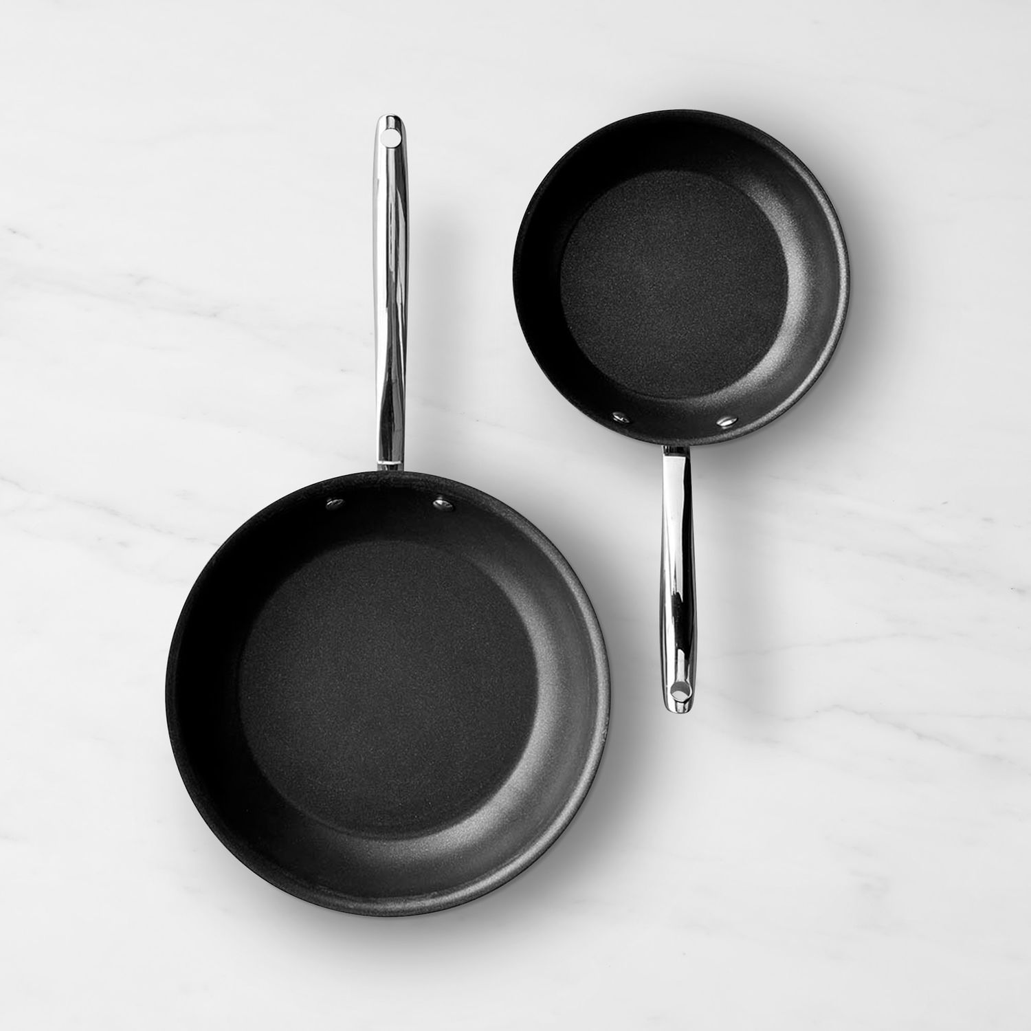 Two frying pans placed on a flat surface