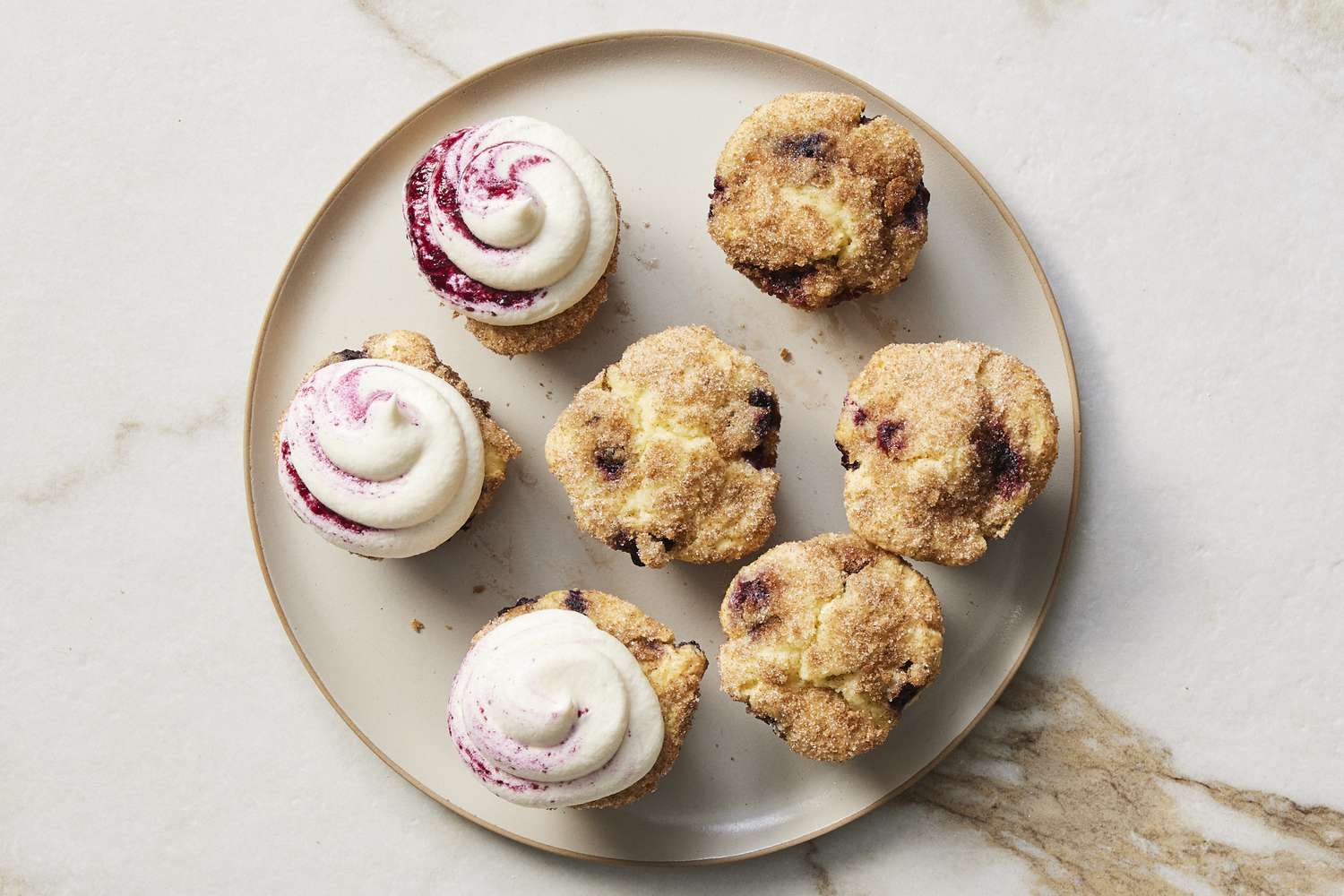 Piped frosting onto blueberry cupcakes