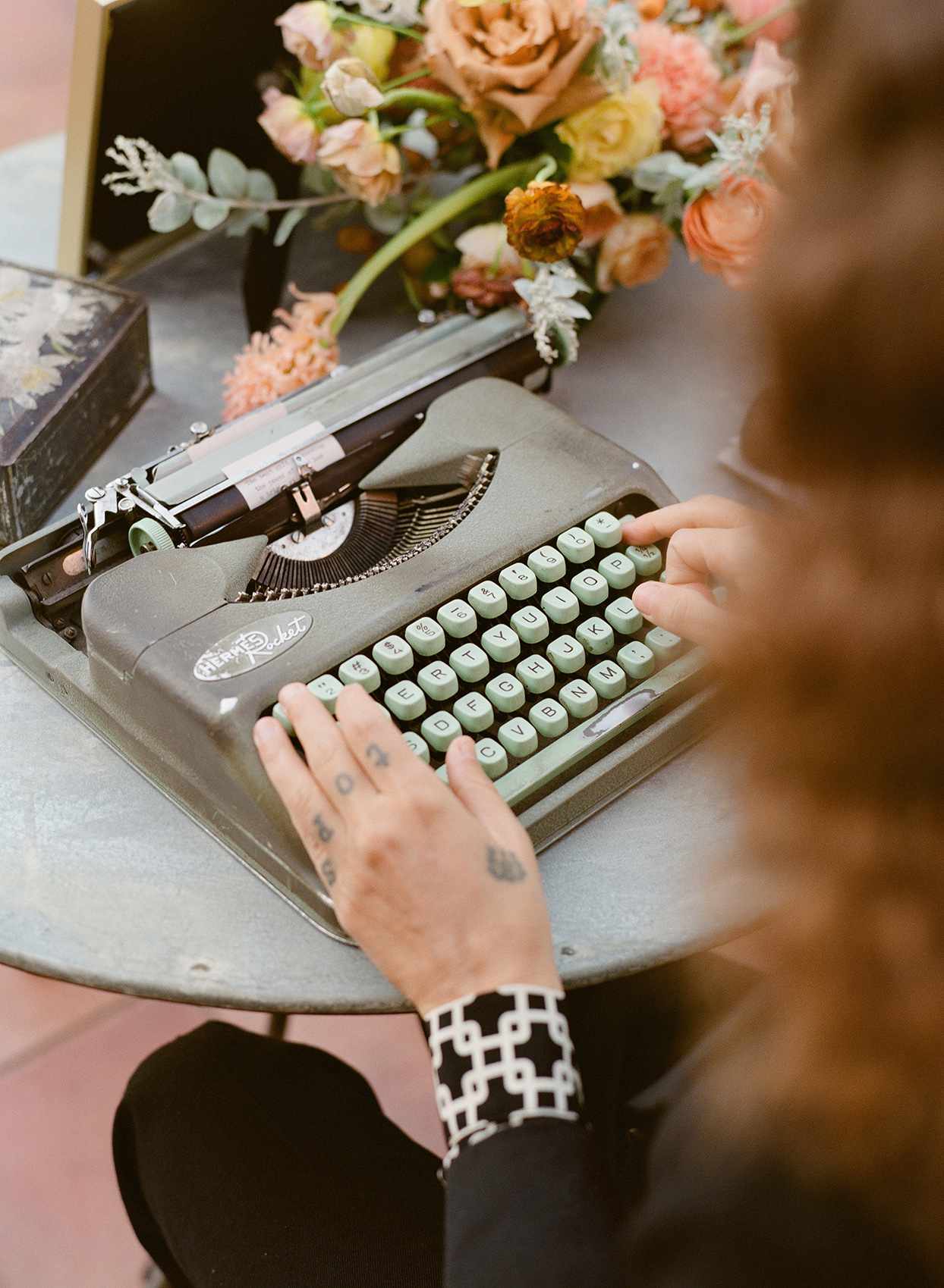 guest typing on wedding typewriter