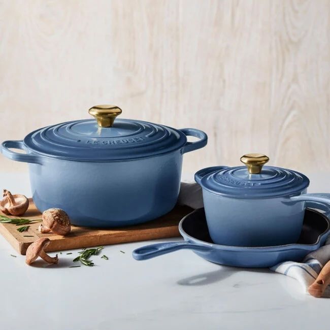 Set of blue cookware including a Dutch oven saucepan and skillet displayed on a countertop