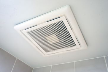 A ceilingmounted ventilation fan in a tiled bathroom