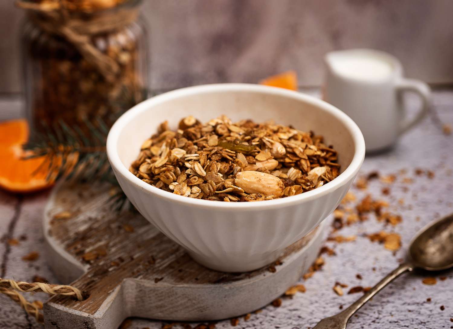 bowl of granola on a cutting board with spoon