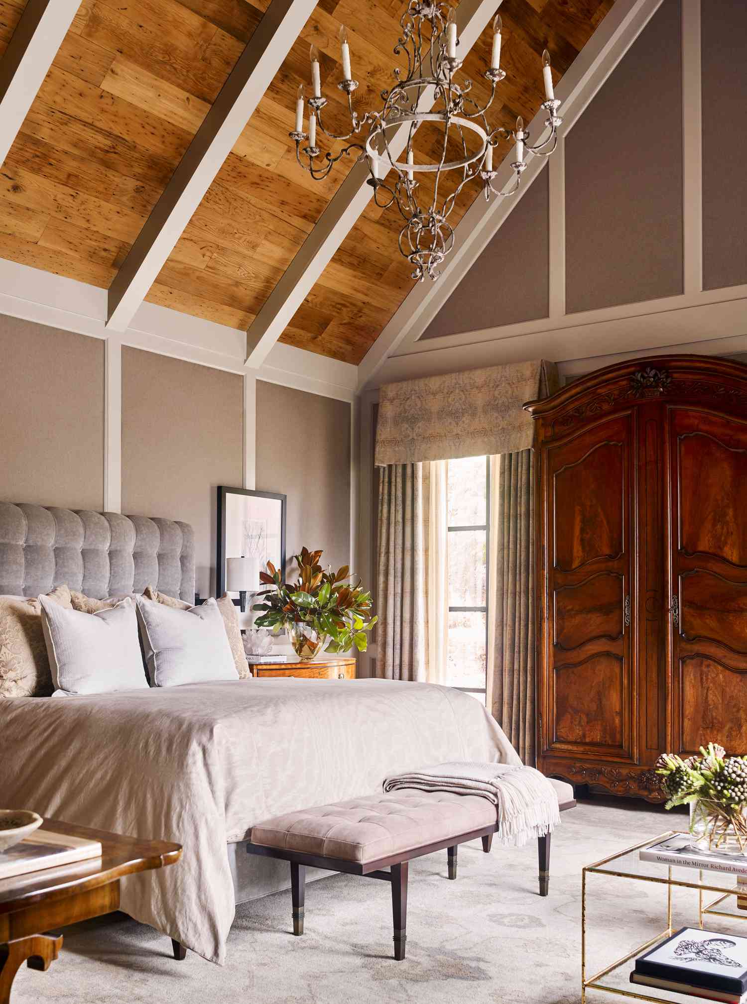 a bedroom with wood ceiling and chandelier 