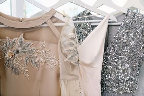 Three elegant dresses hanging featuring intricate embellishments and sparkling details