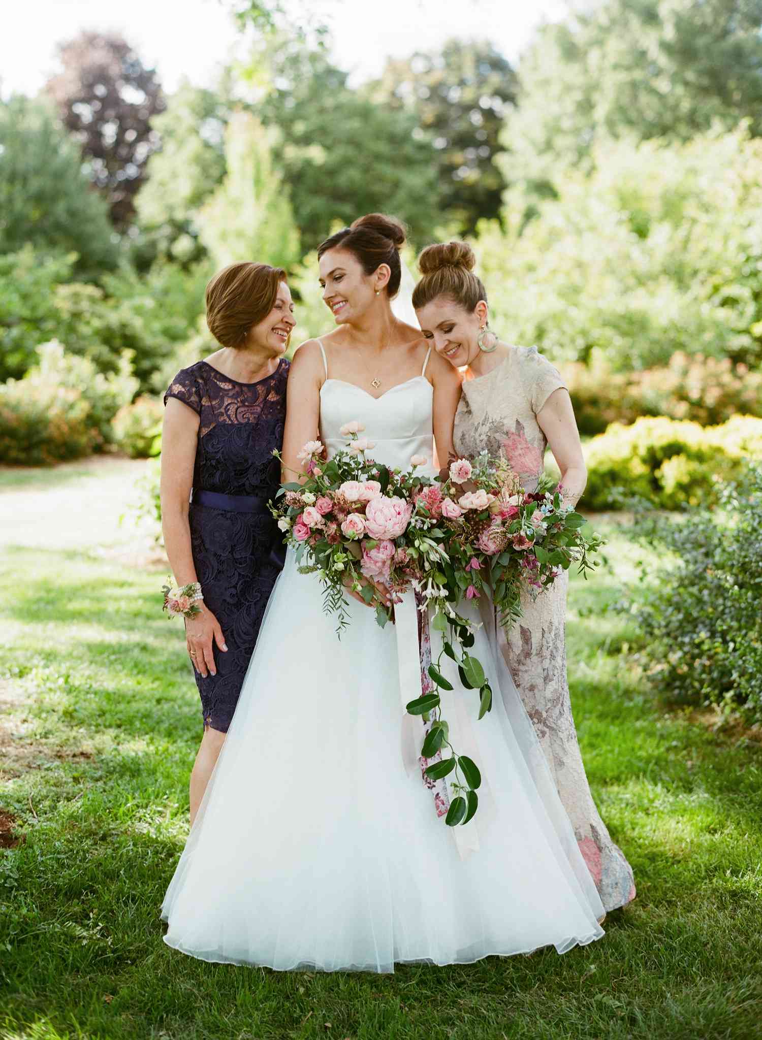 Bride poses with maid of honor and the mother of the bride
