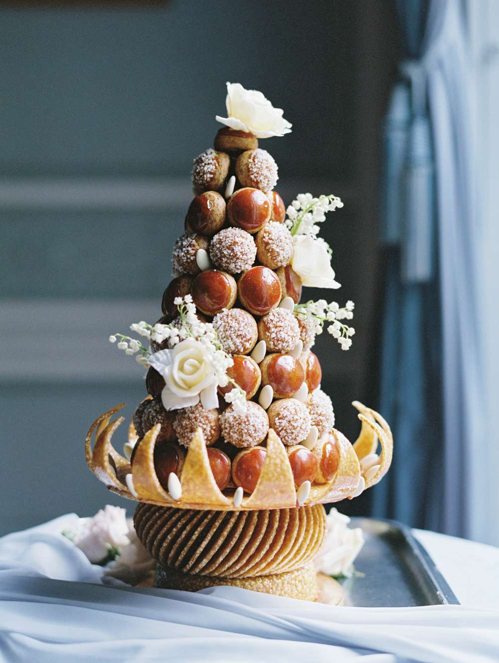 wedding croquembouche dessert adorned with white roses