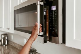 woman opening microwave