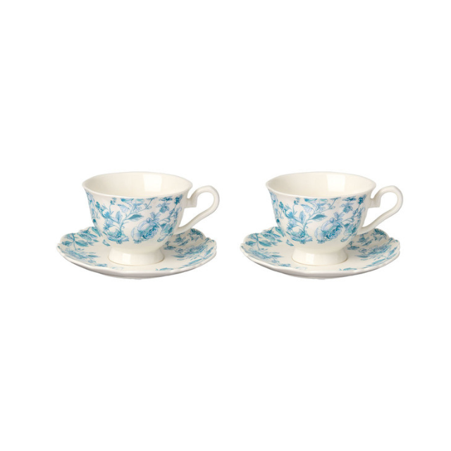 A matching set of two teacups with floral patterns each on a saucer