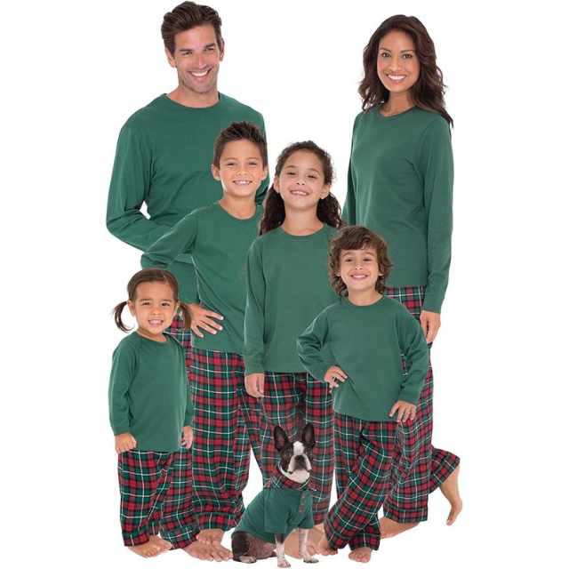 A family group with six members and a dog all wearing matching green tops and plaid pants