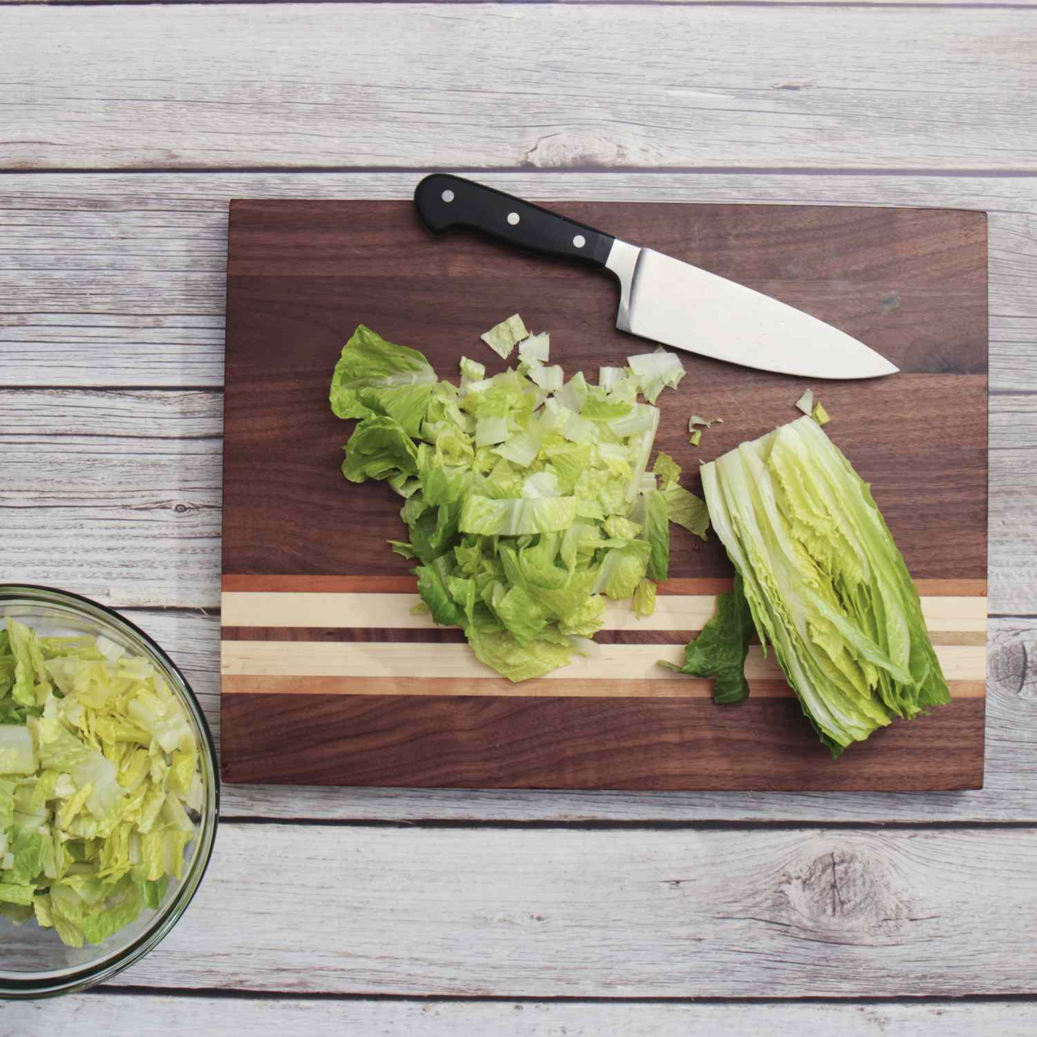 Sliced lettuce and a knife on the Sonder Los Angeles Large Multipurpose American Walnut Wood Cutting Board