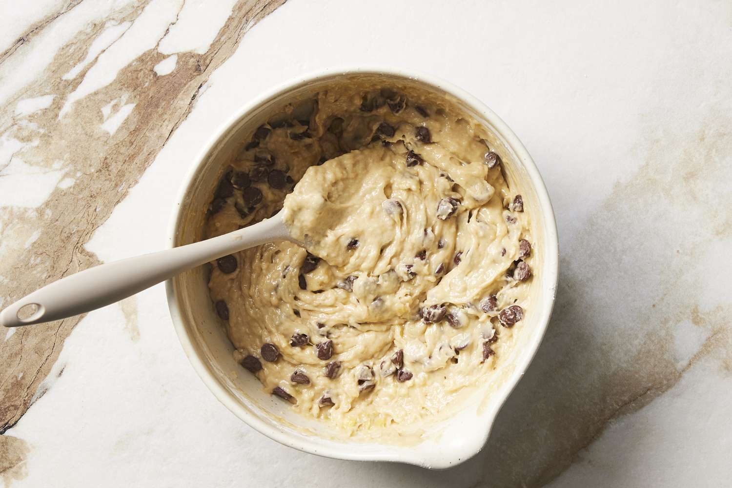 Chocolate chip dough in bowl with whisk