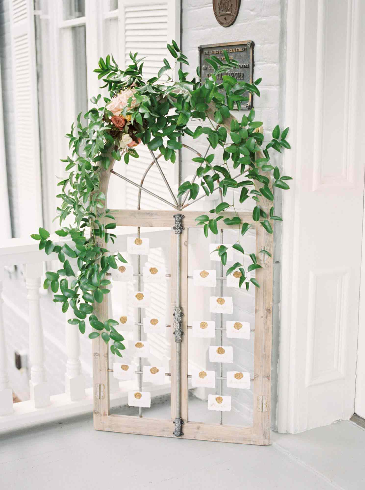 greenery garland arched above seating chart
