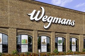 Exterior view of a Wegmans store with its logo displayed on the brick facade