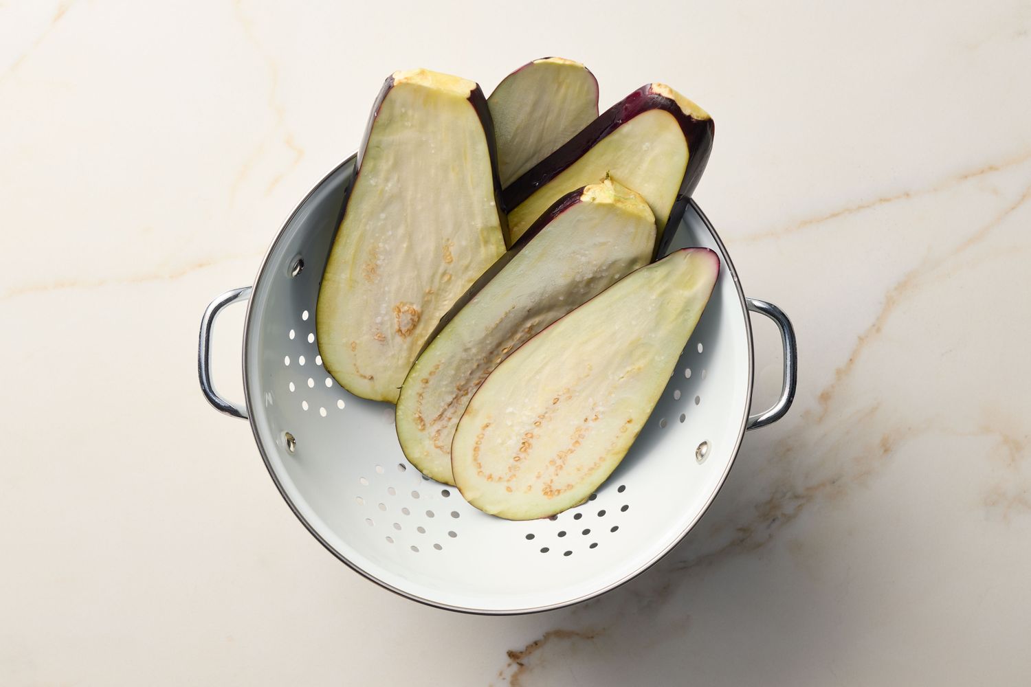 Sliced eggplants arranged in a colander