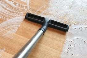 Woman mopping/vacuuming hardwood floors to prevent mold