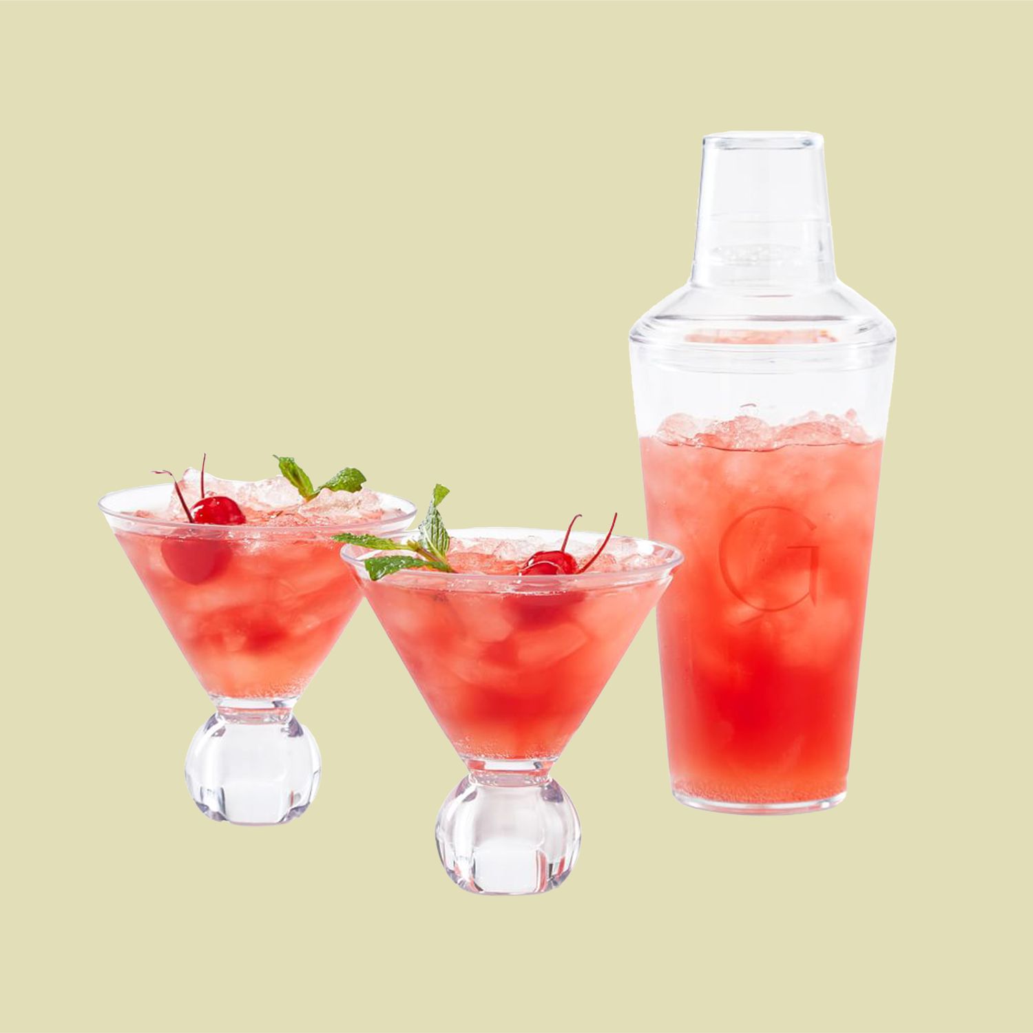 two martini glasses and a shaker with red liquid