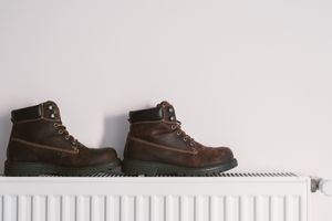 A pair of boots resting on a radiator