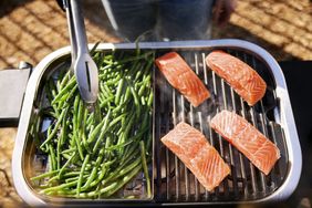 salmon and green beans cooking on an electric grill outdoors