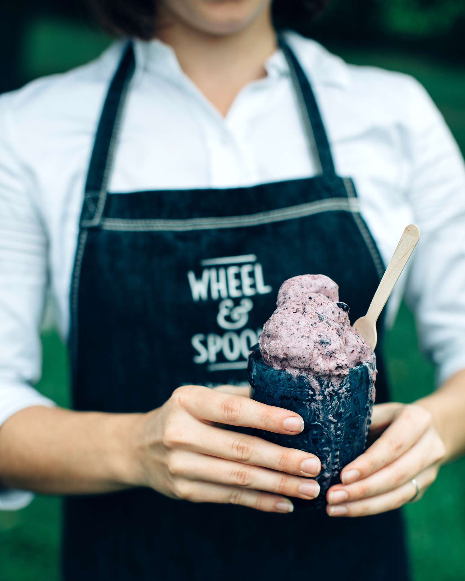 wheel and spoon employee holding ice cream in dark cup