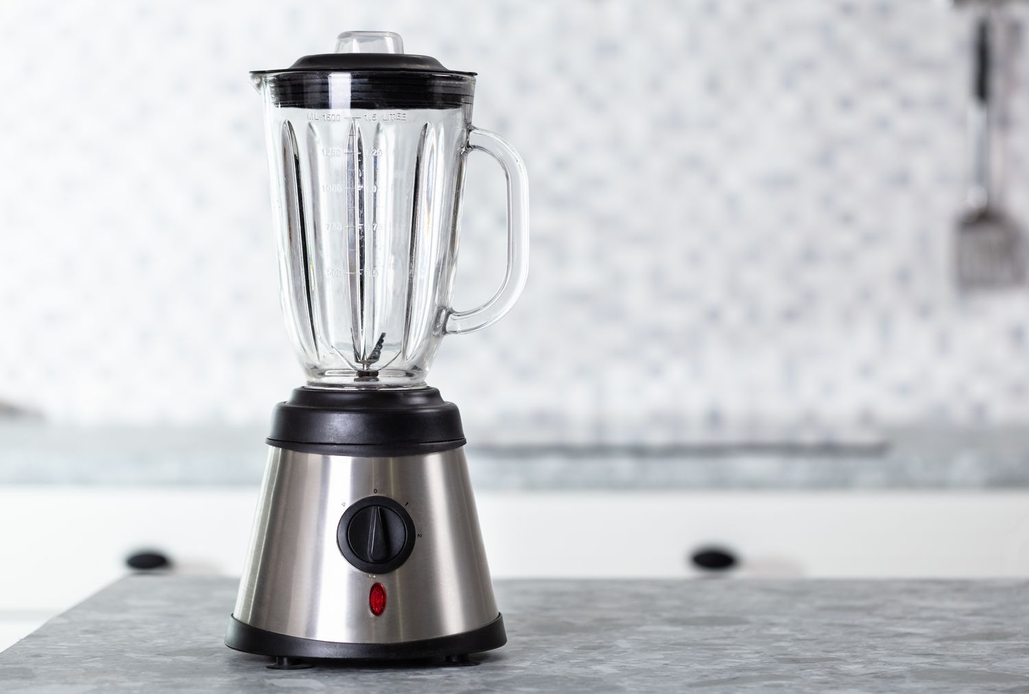 A countertop blender with a glass jar and stainless steel base on a kitchen counter