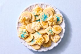 An assortment of butter cookies with decorative sprinkles on a white plate