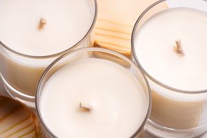 Closeup view of three candles in glass containers arranged on a table