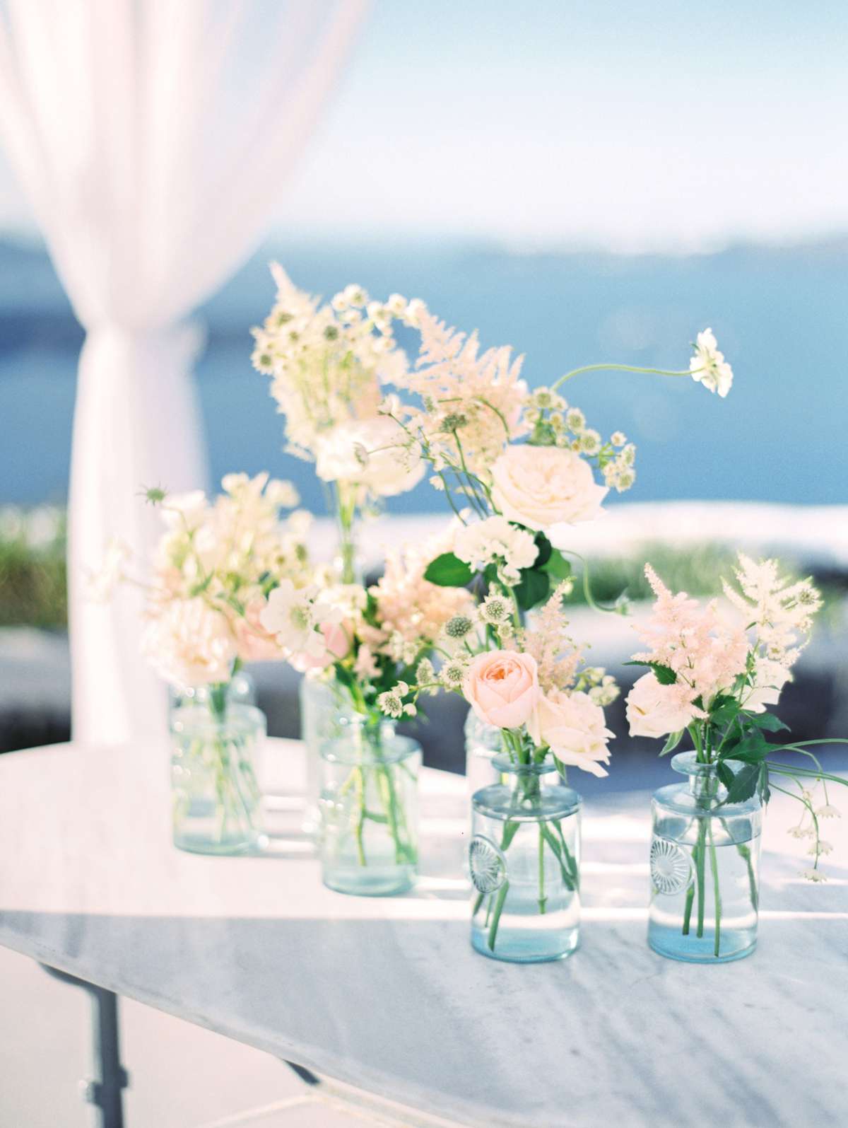 pink roses and white flowers in glass vases