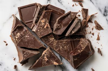 Chunks of broken chocolate on a marble surface