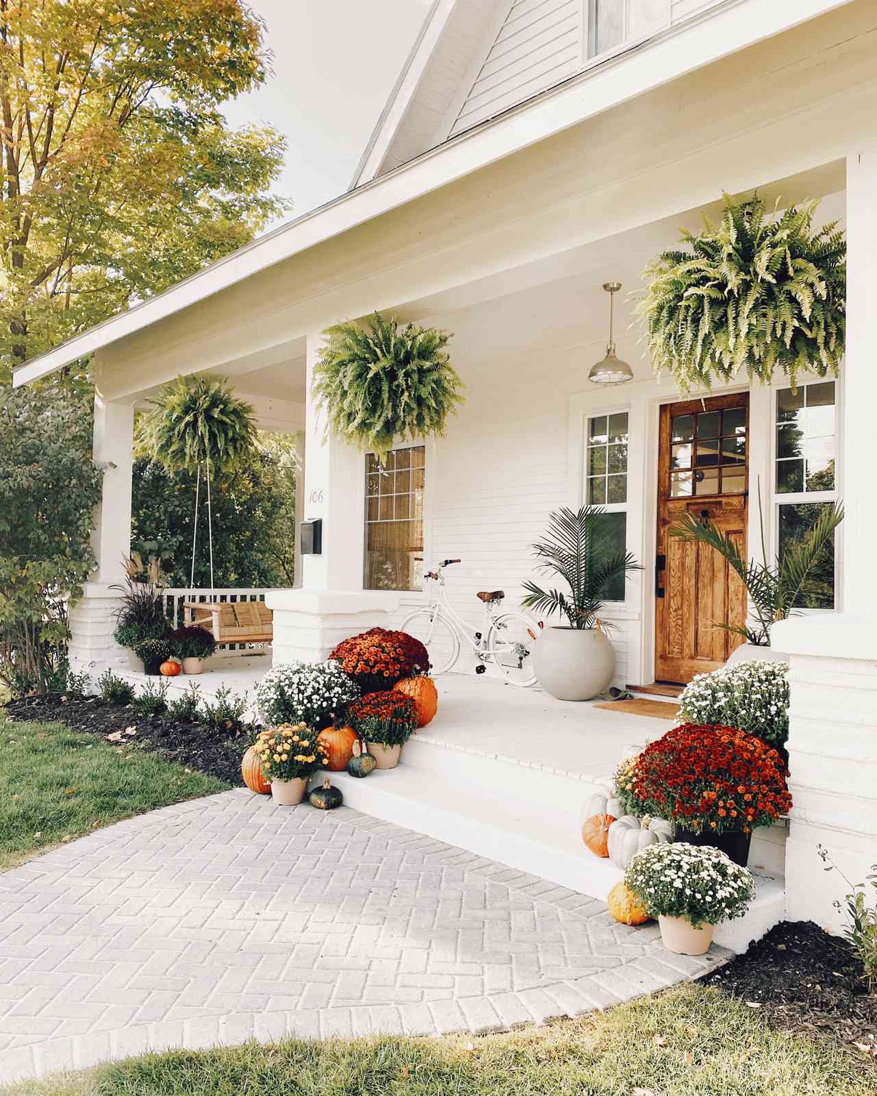 fall porch with colorful mums pumpkins gourds