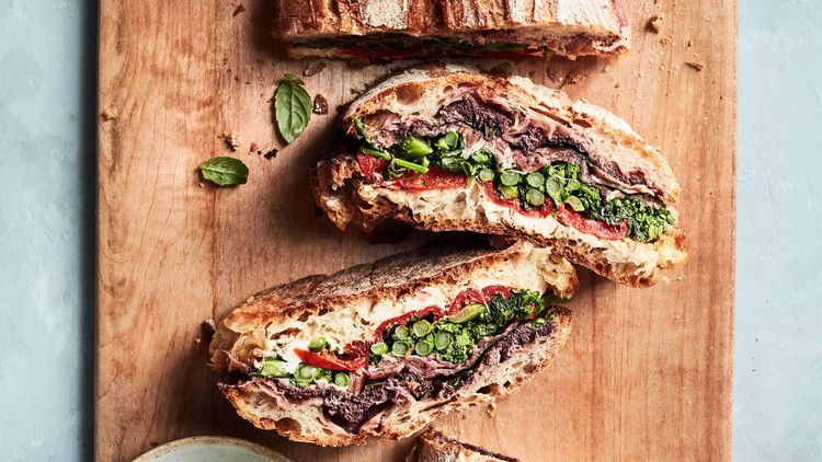 pressed sandwich with prosciutto and broccoli rabe recipe on wooden cutting board