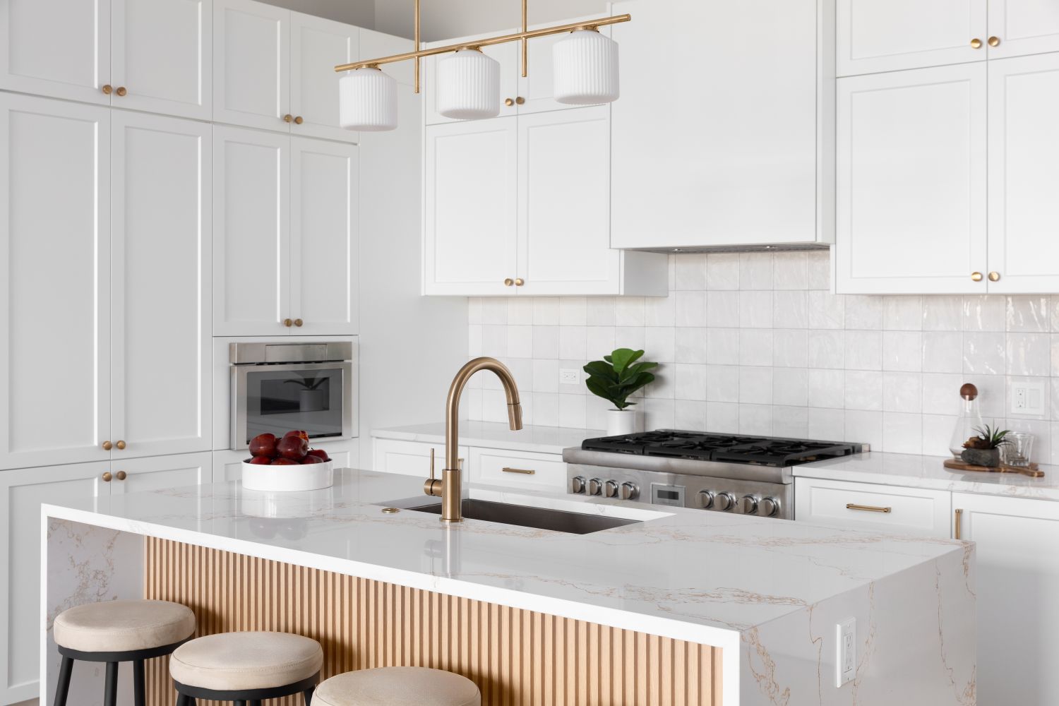 Modern kitchen design with a central island featuring a gold faucet white cabinets and builtin appliances minimalistic decor