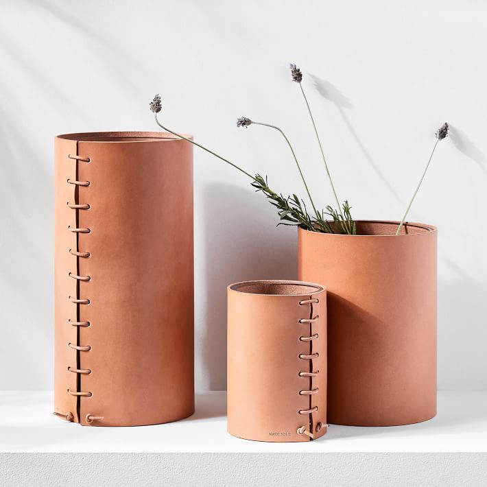 three leather-wrapped vases