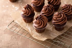 chocolate cupcakes with chocolate frosting on cooling rack