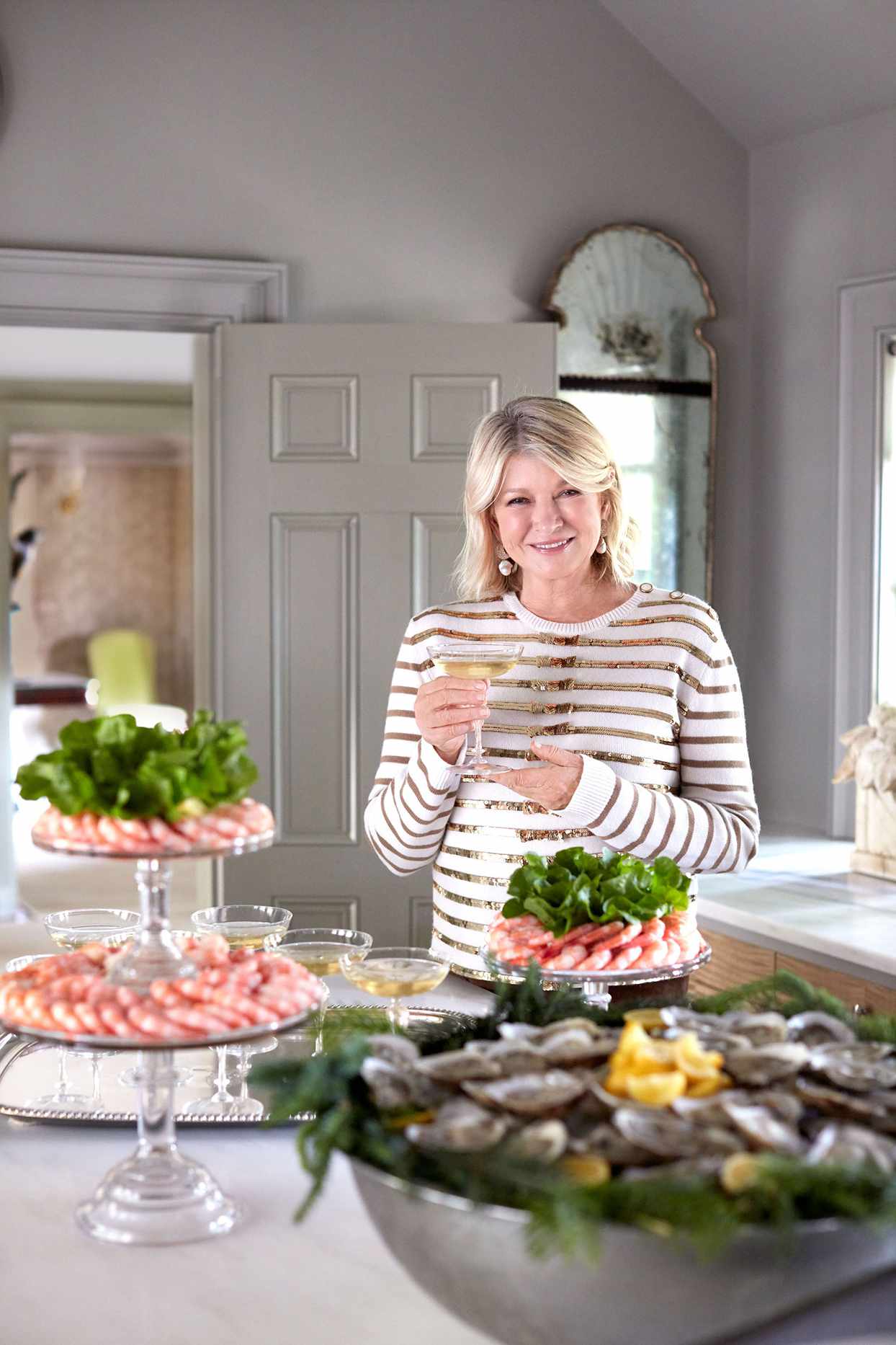 martha holding cocktails by table of seafood