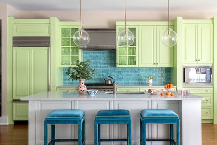Kitchen with pastel green cabinets and a blue tile backsplash