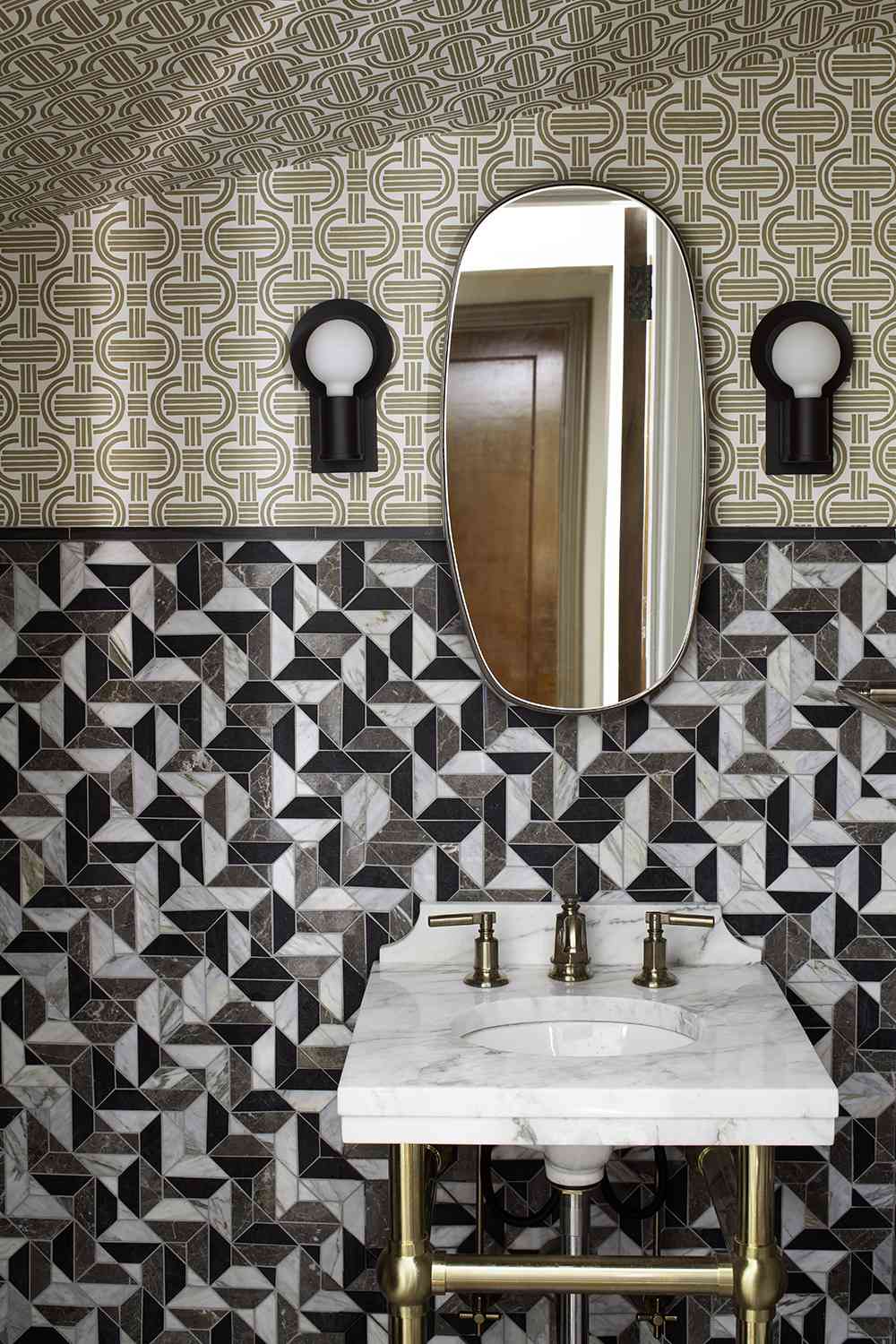 powder bath with geometric tile backsplash and patterned wallpaper