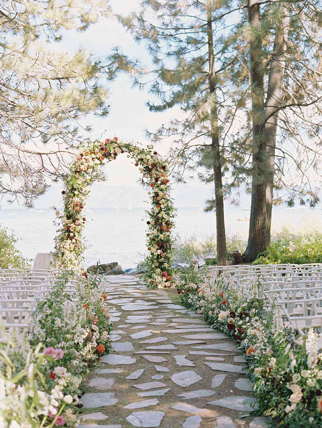 outdoor wedding ceremony location with wildflower arch overlooking lake