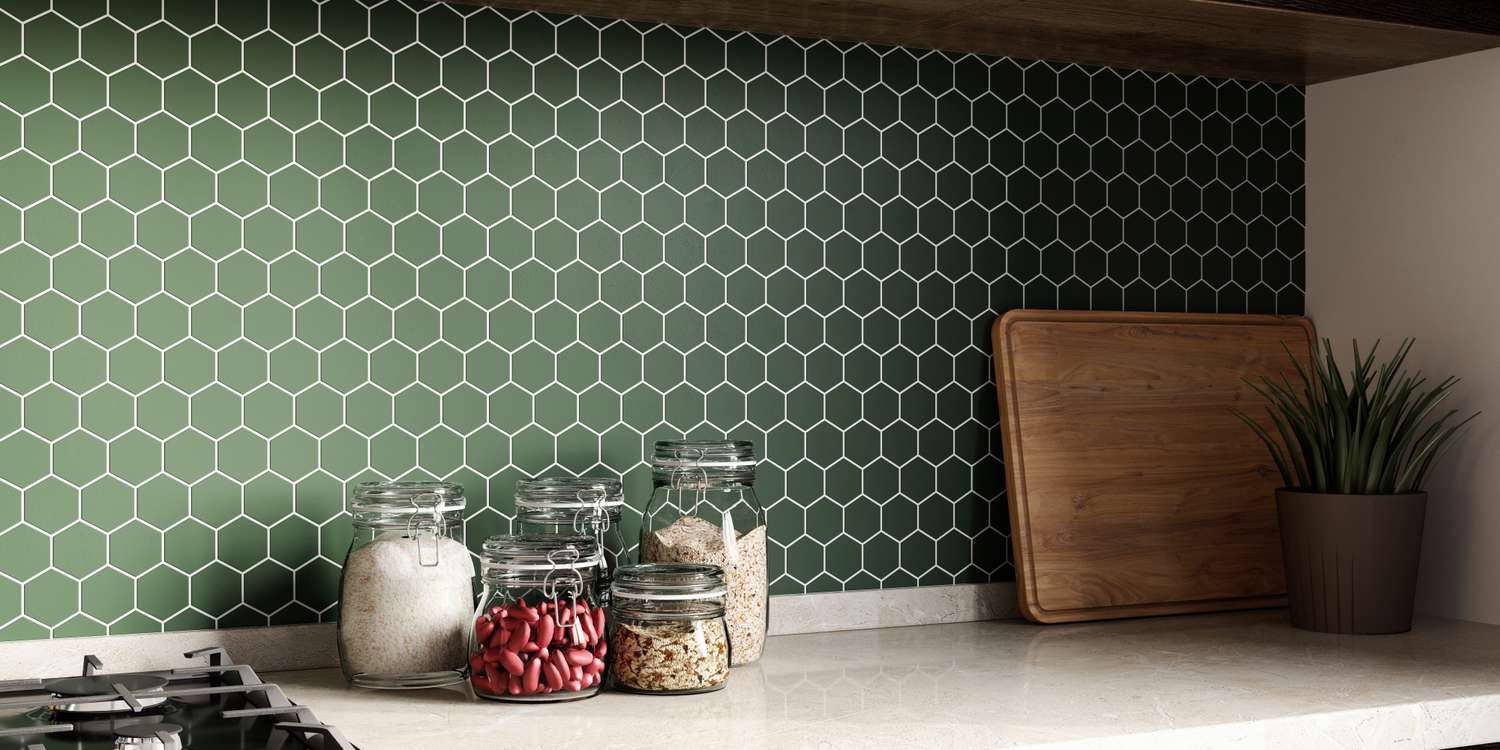 Kitchen counter with jars and a cutting board against a hexagonal tiled backsplash