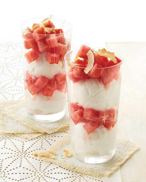 Two glasses of parfait layered with white and red ingredients topped with coconut flakes