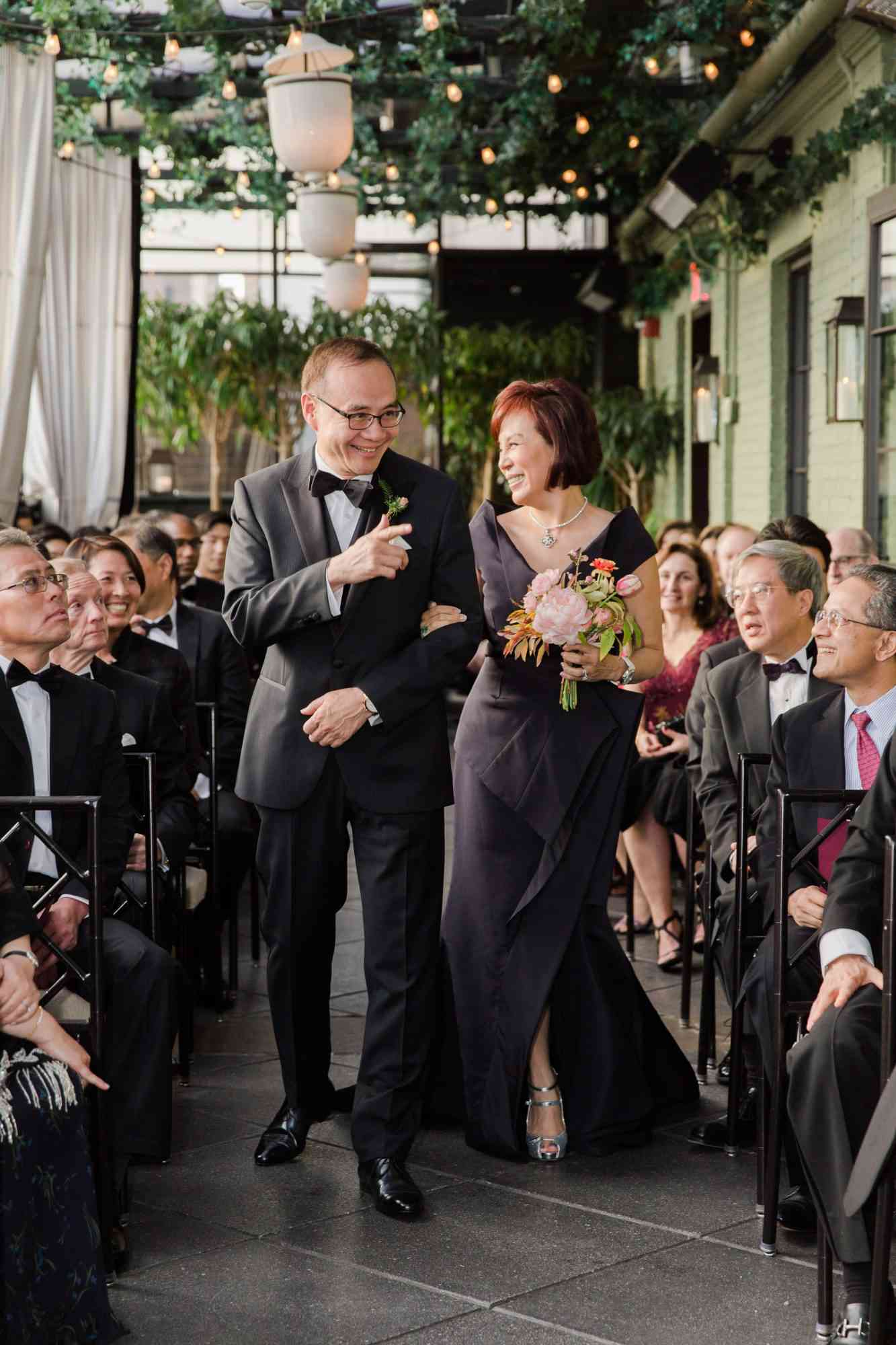 The mother of the groom and father of the groom walking down the aisle
