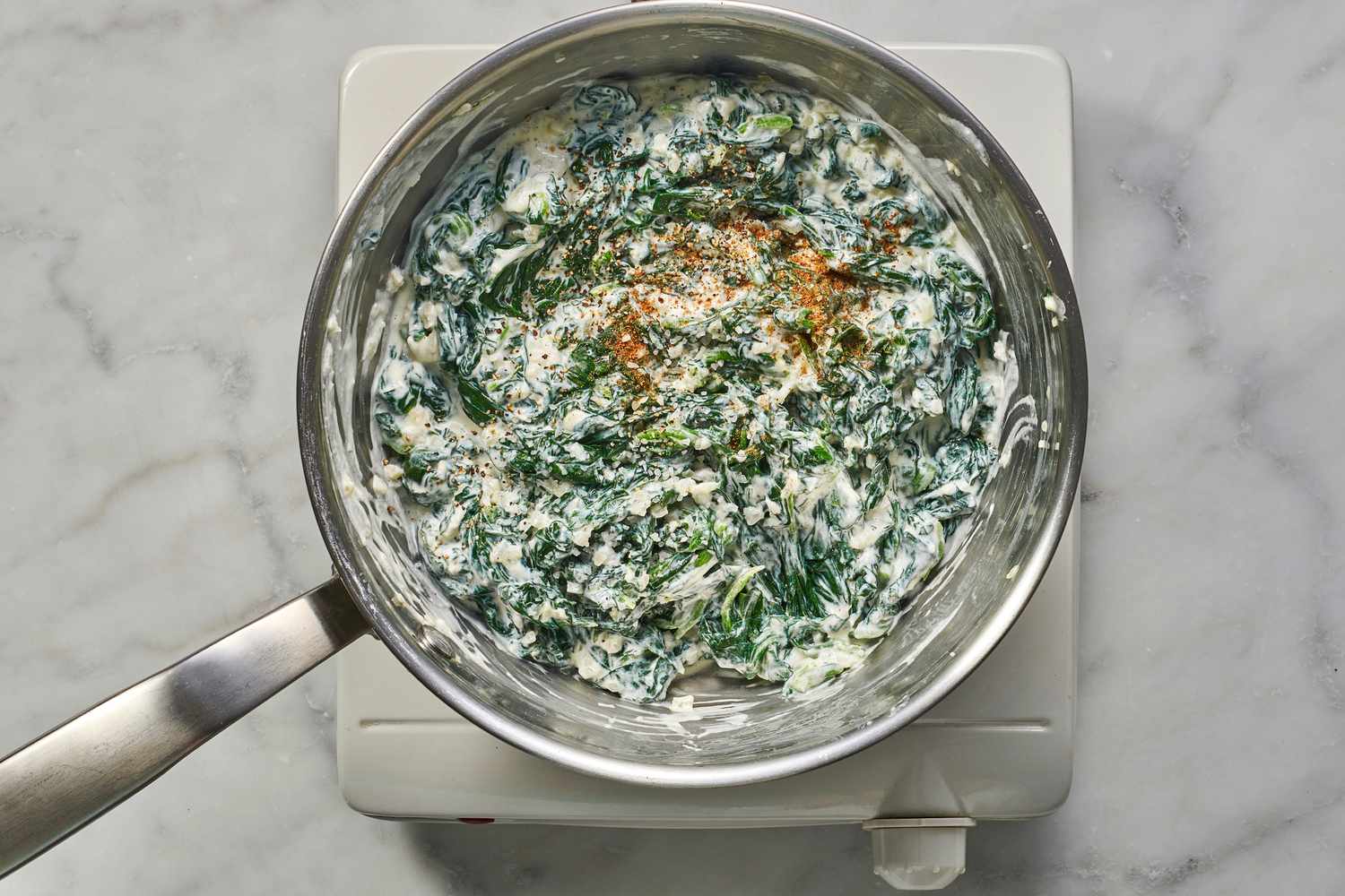 adding nutmeg to creamed spinach