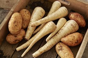 russet potatoes and parsnips in a wooden crate