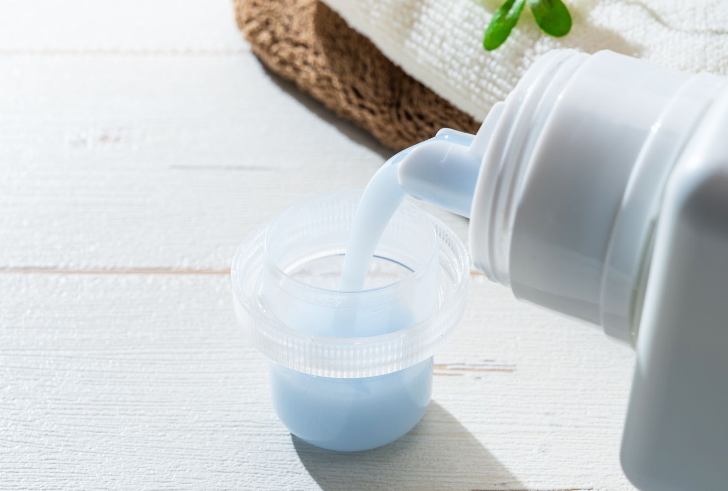Pouring liquid laundry detergent into a measuring cap