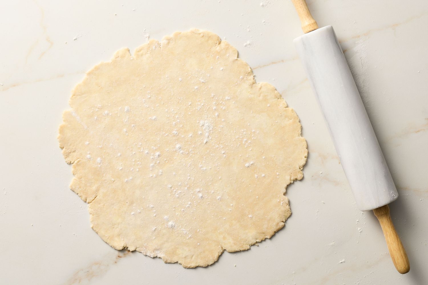 Rolling pin next to rolled-out dough